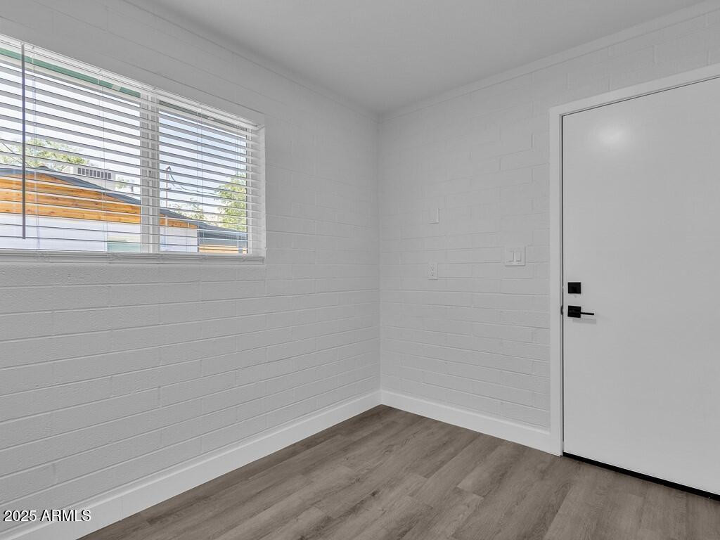 3116 North 39th Street Phoenix, AZ 85018 - Photo 11 of 22 a view of an empty room with wooden floor and a window