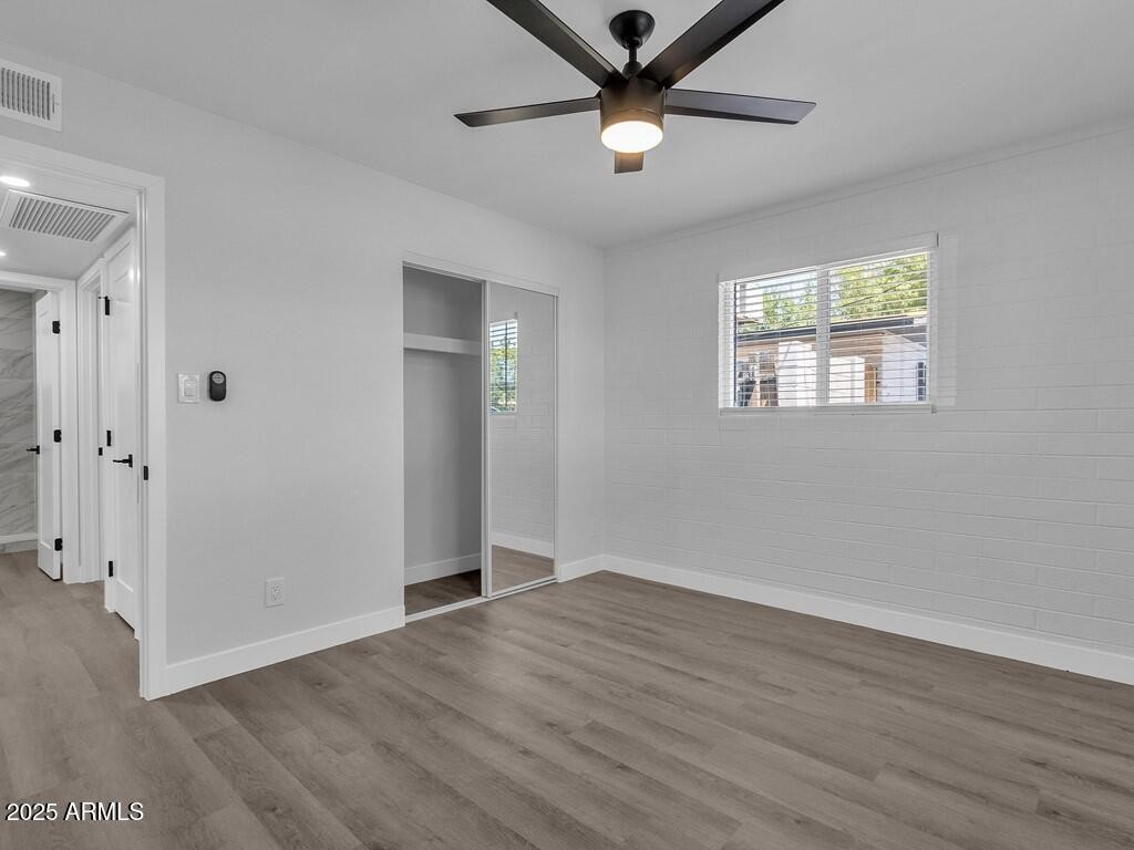3116 North 39th Street Phoenix, AZ 85018 - Photo 14 of 22 an empty room with wooden floor and windows