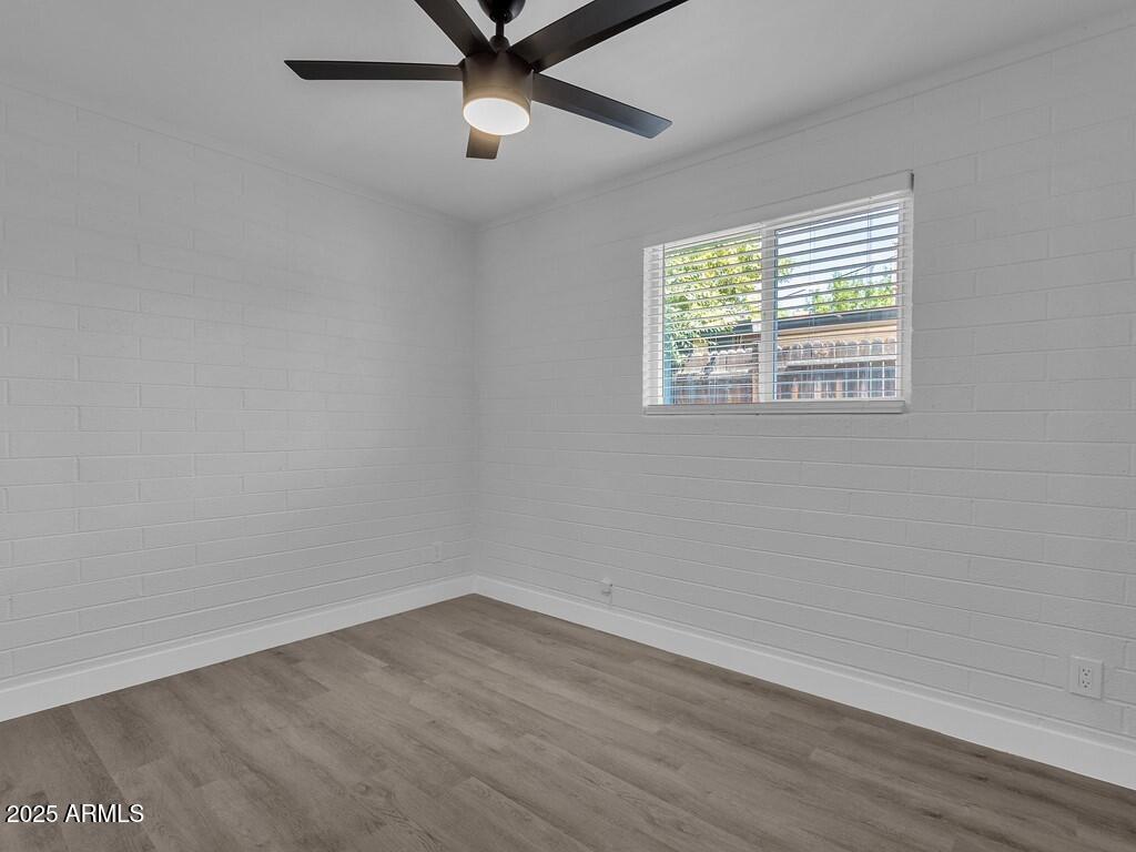 3116 North 39th Street Phoenix, AZ 85018 - Photo 15 of 22 an empty room with wooden floor ceiling fan and windows