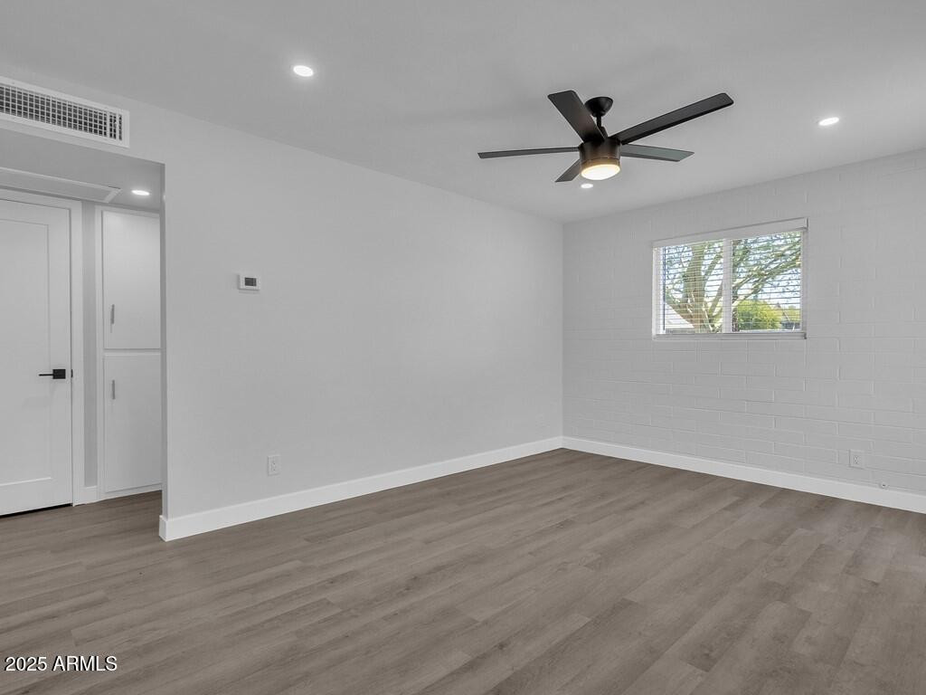 3116 North 39th Street Phoenix, AZ 85018 - Photo 5 of 22 an empty room with wooden floor and windows