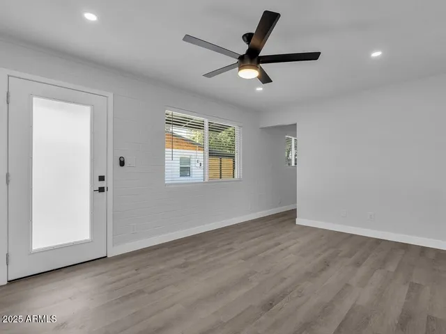 a view of a livingroom with a ceiling fan and wooden floor