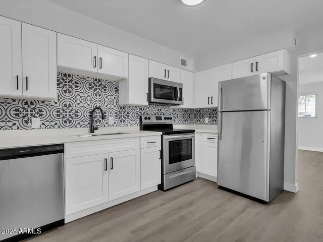 a kitchen with a refrigerator stove and sink