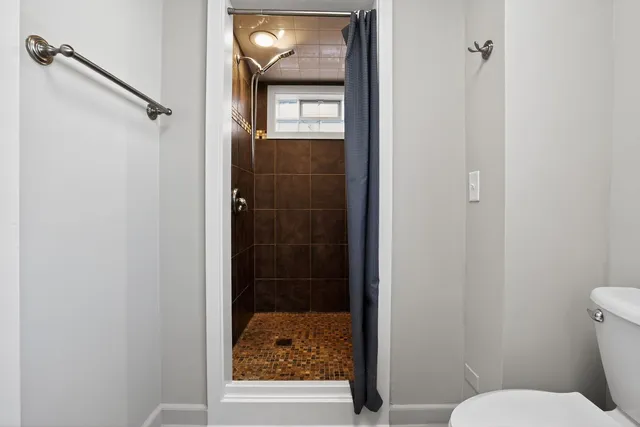 a bathroom with a toilet and a shower