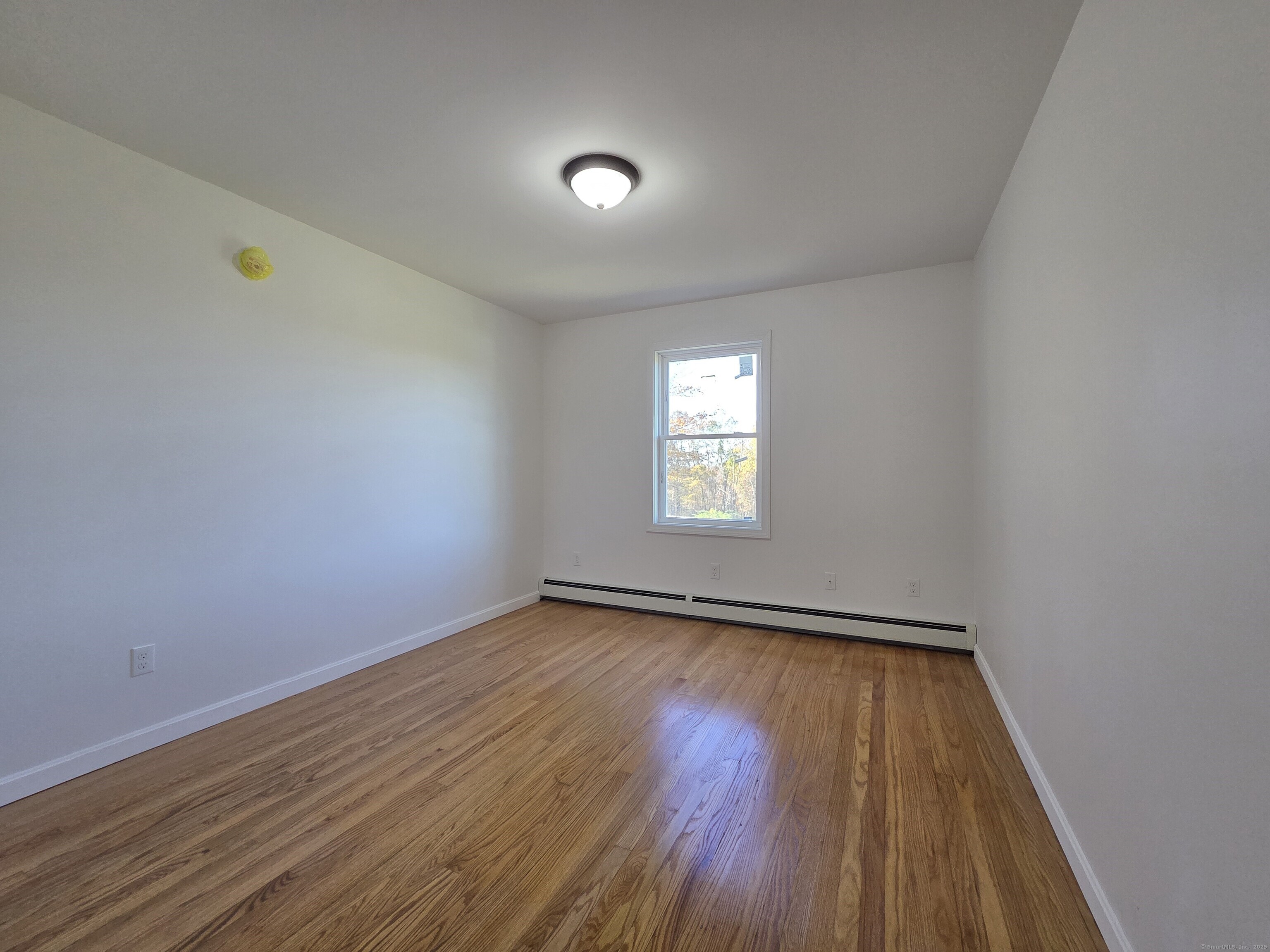 395 Bailey Hill Road Killingly, CT 06239 - Photo 16 of 36 a view of an empty room with wooden floor and a window