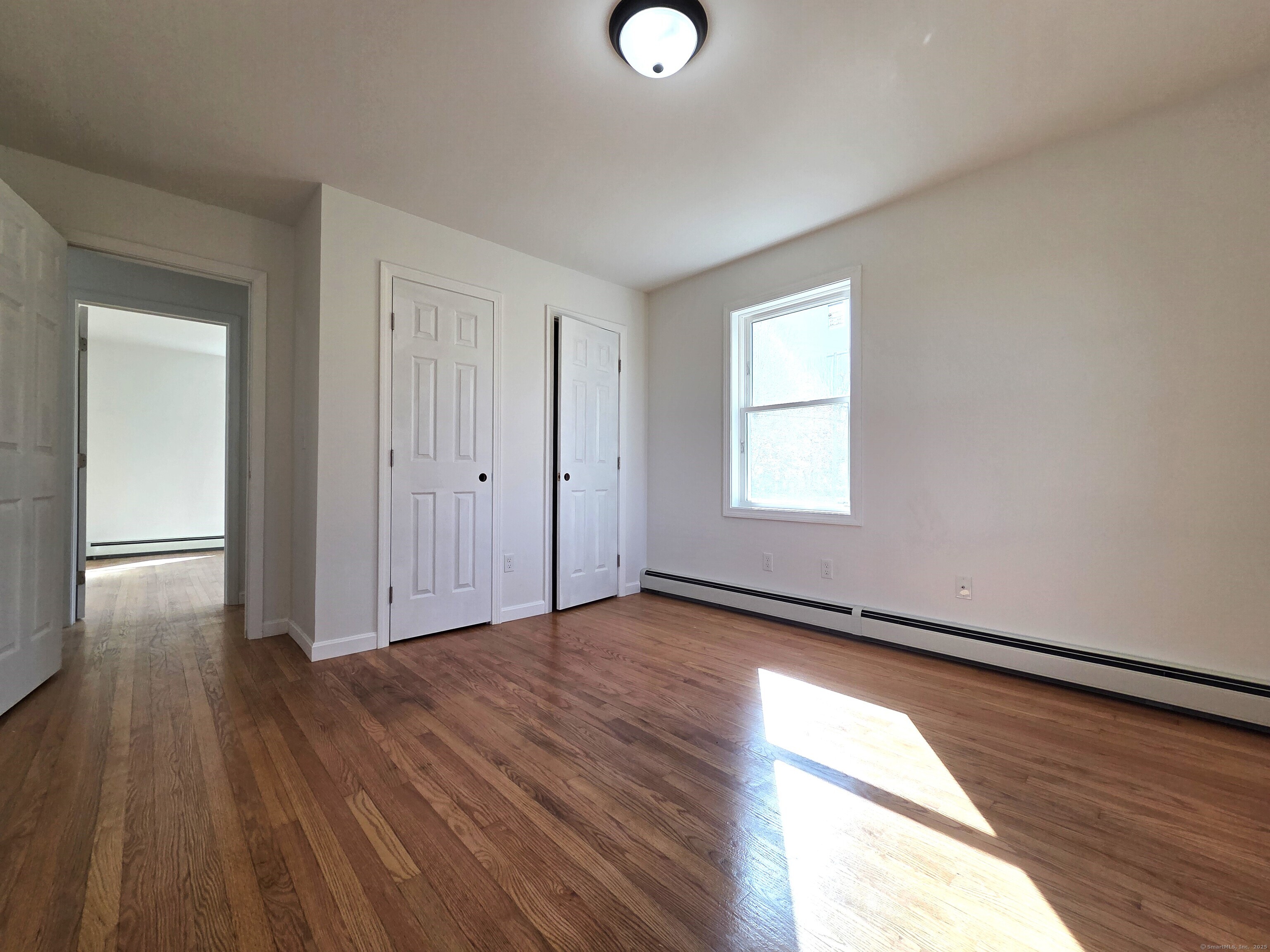 395 Bailey Hill Road Killingly, CT 06239 - Photo 18 of 36 an empty room with wooden floor and windows