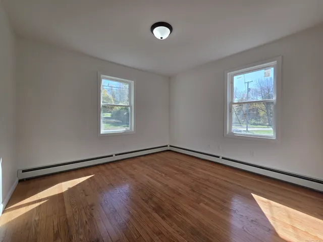 a view of a room with wooden floor and window