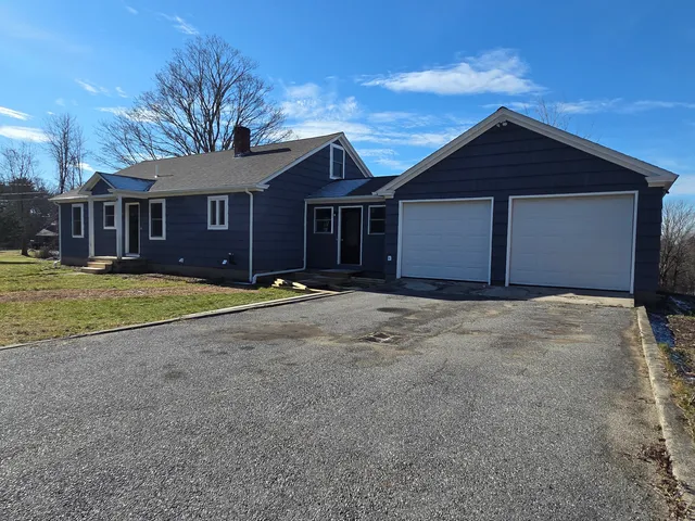 a view of a house with a yard and large tree