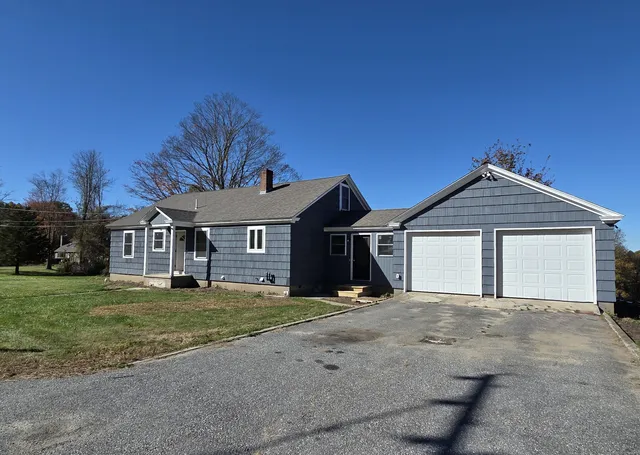 a view of a yard in front of a house with a large tree