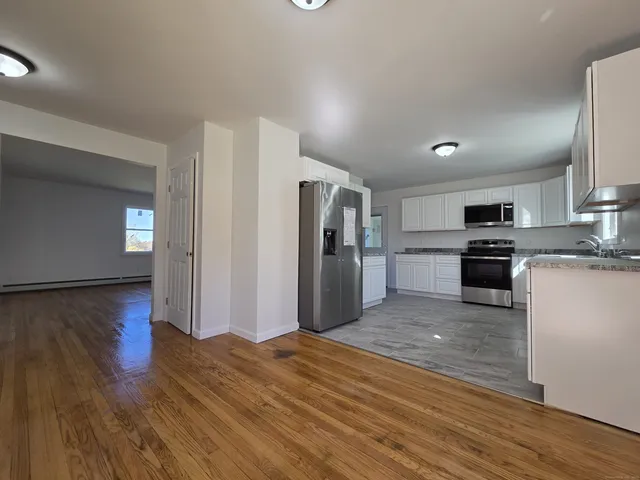 a kitchen with stainless steel appliances granite countertop a refrigerator sink and stove