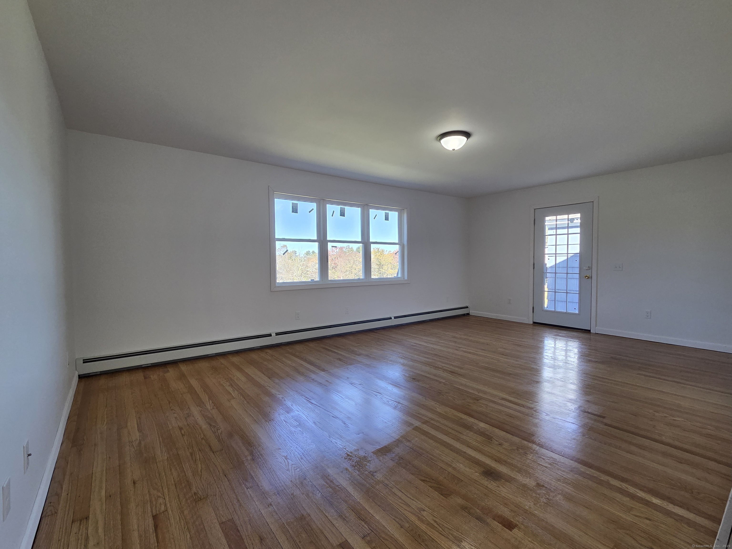 395 Bailey Hill Road Killingly, CT 06239 - Photo 10 of 36 an empty room with wooden floor and windows