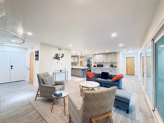 a living room with furniture and kitchen view