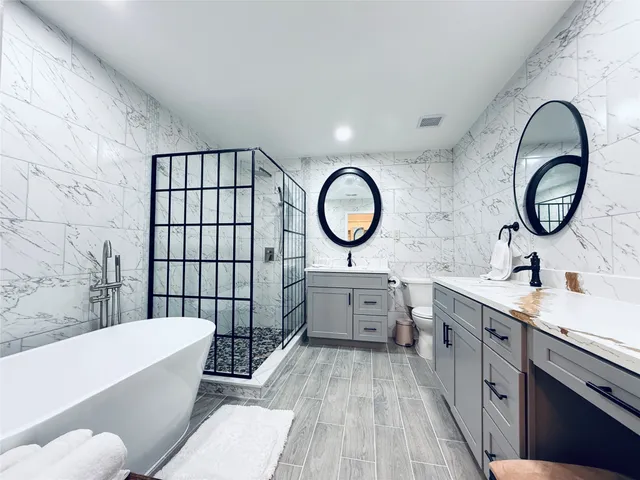 a bathroom with a tub a double vanity sink and a mirror