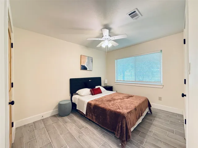 a bedroom with a bed chandelier and a window
