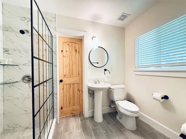 a bathroom with a sink a toilet and shower