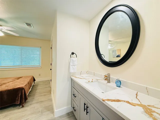 a en suite bathroom with a granite countertop double vanity and a mirror