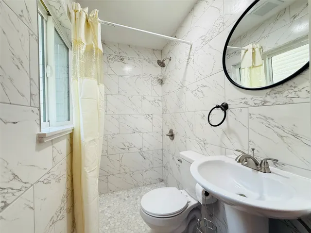 a bathroom with a sink toilet and mirror