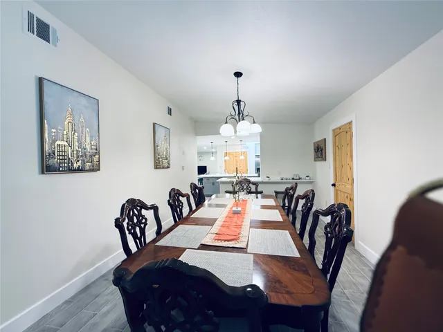 a view of a a dining room with furniture window and wooden floor