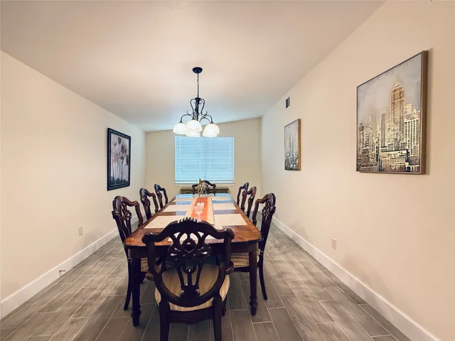 a view of a dining room with furniture wooden floor and chandelier