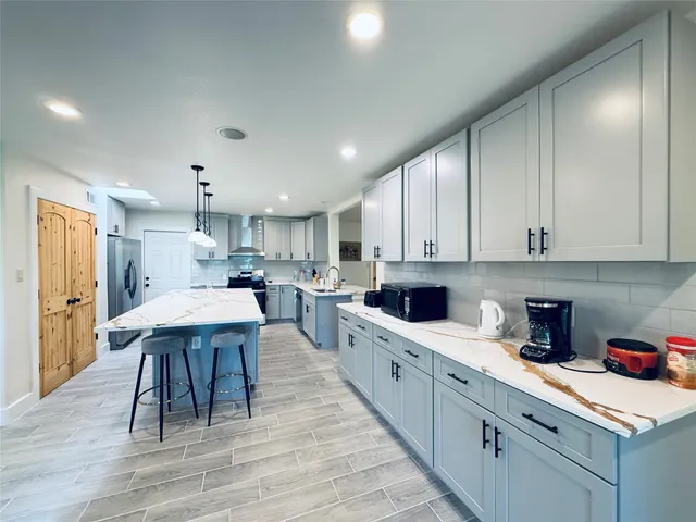 a kitchen with a sink a cabinets and wooden floor