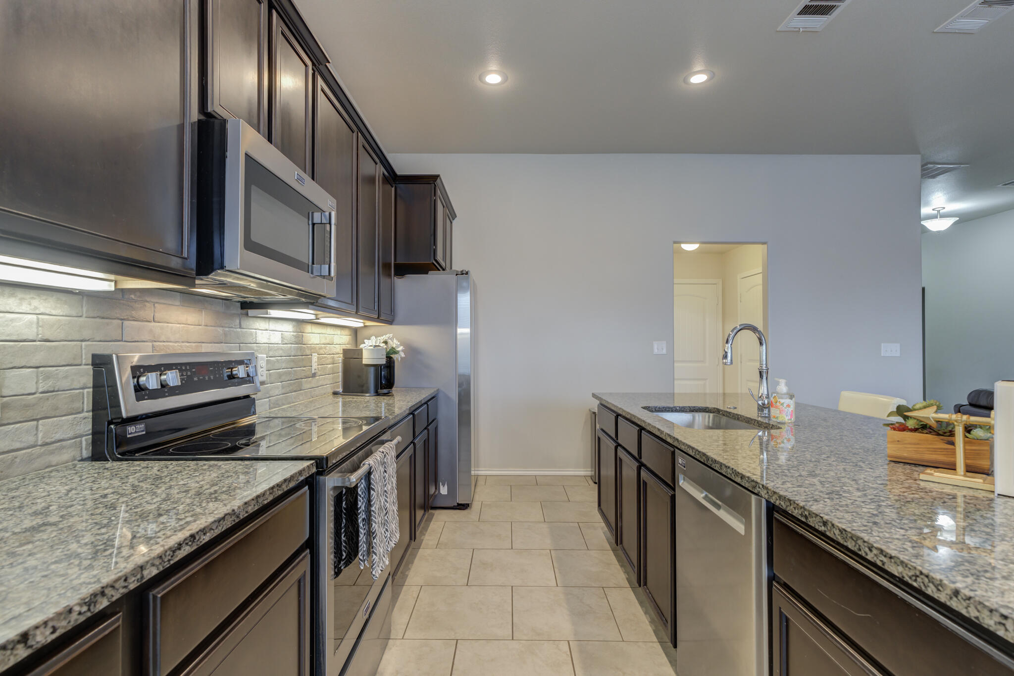 7201 94th Street Lubbock, TX 79424 - Photo 13 of 34 a kitchen with stainless steel appliances granite countertop a sink and stove