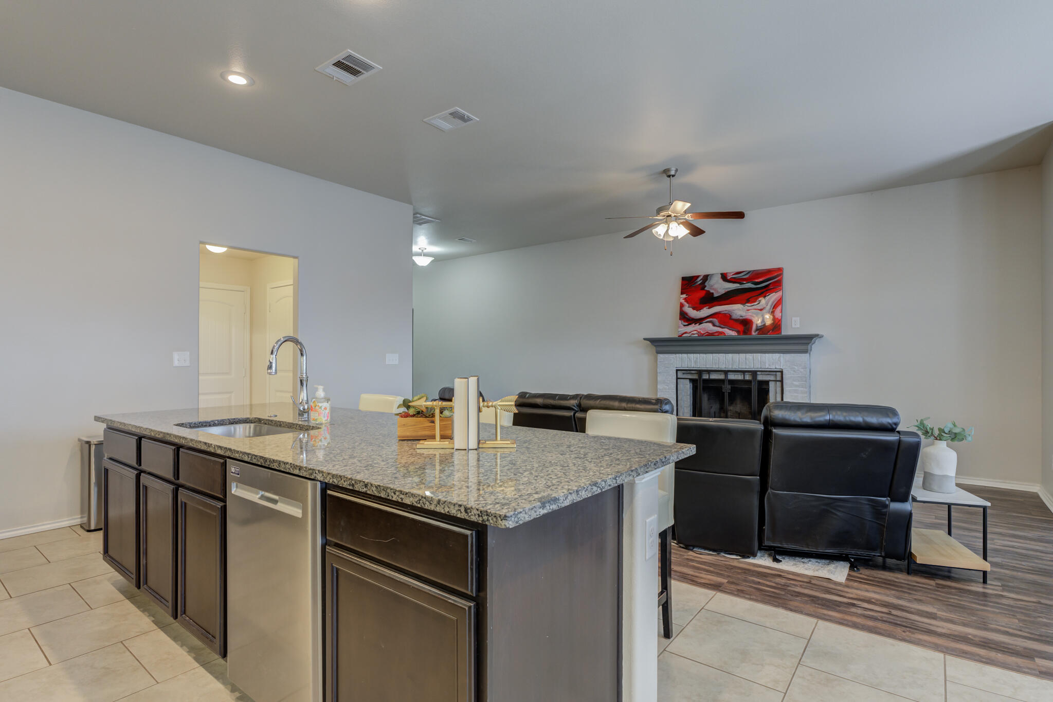 7201 94th Street Lubbock, TX 79424 - Photo 15 of 34 a kitchen with a sink cabinets and wooden floor