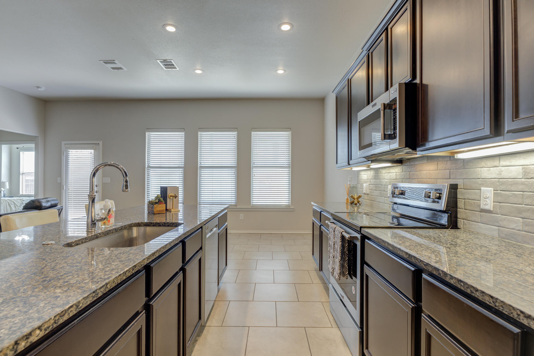 7201 94th Street Lubbock, TX 79424 - Photo 16 of 34 a kitchen with granite countertop a sink and a stove