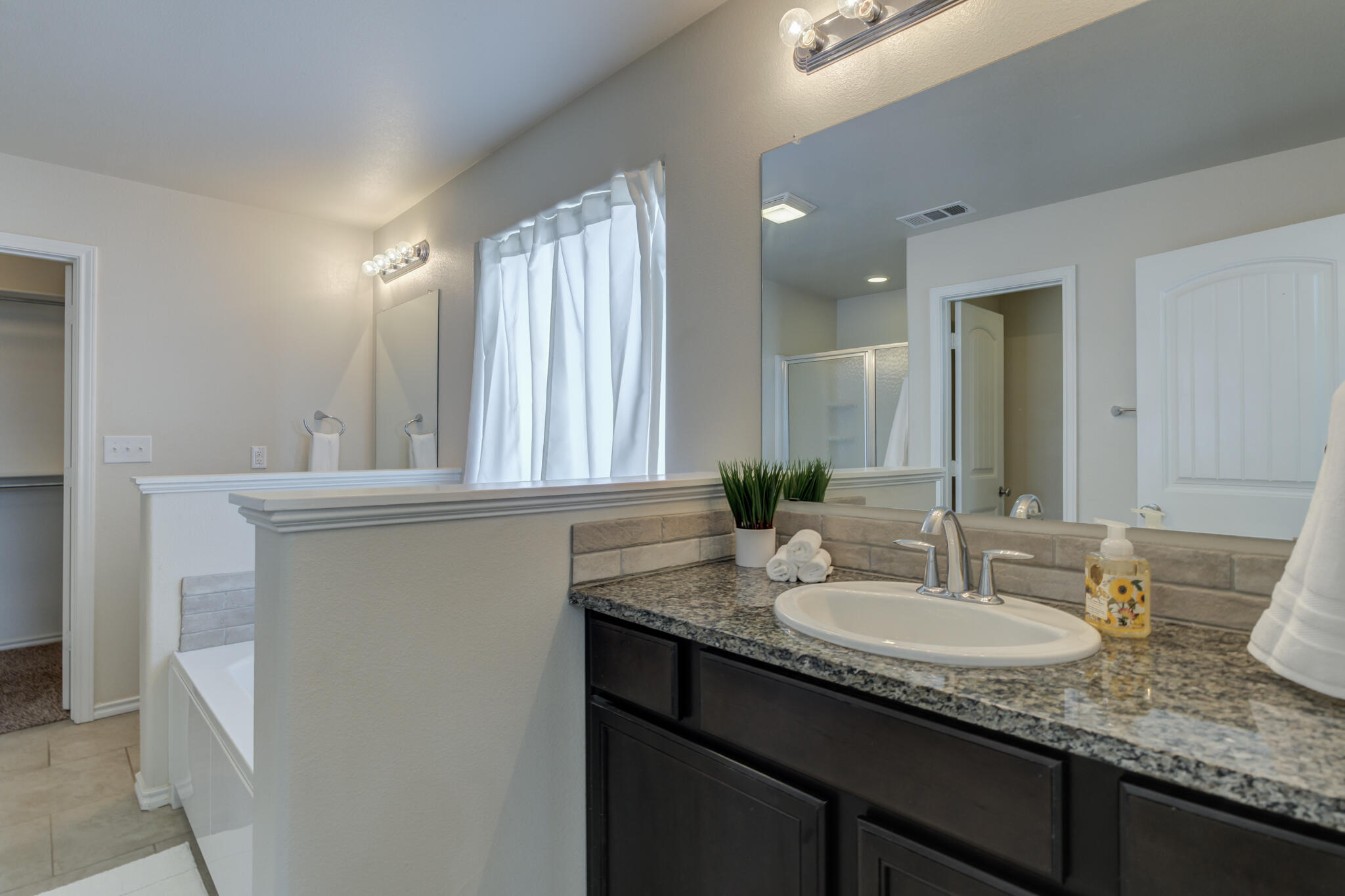 7201 94th Street Lubbock, TX 79424 - Photo 21 of 34 a bathroom with a granite countertop sink and a mirror