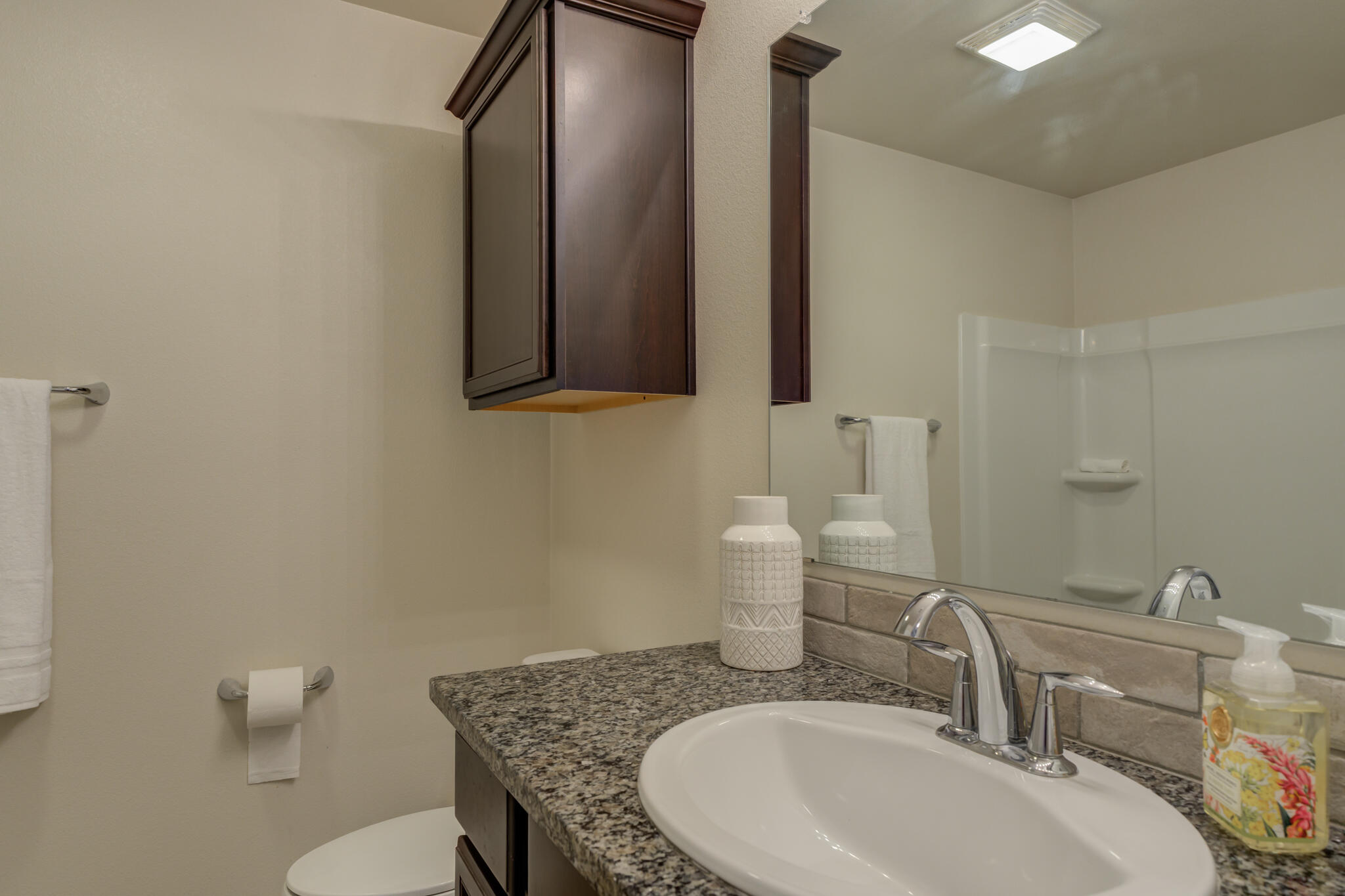7201 94th Street Lubbock, TX 79424 - Photo 26 of 34 a bathroom with a granite countertop toilet sink and mirror
