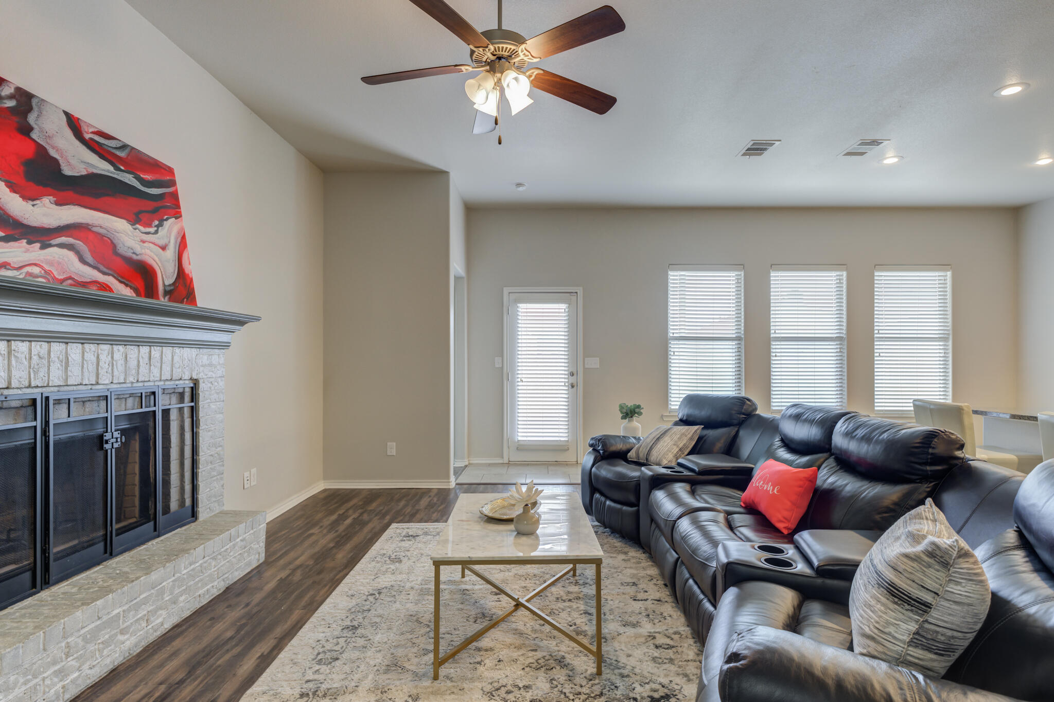 7201 94th Street Lubbock, TX 79424 - Photo 5 of 34 a living room with furniture a fireplace and a chandelier