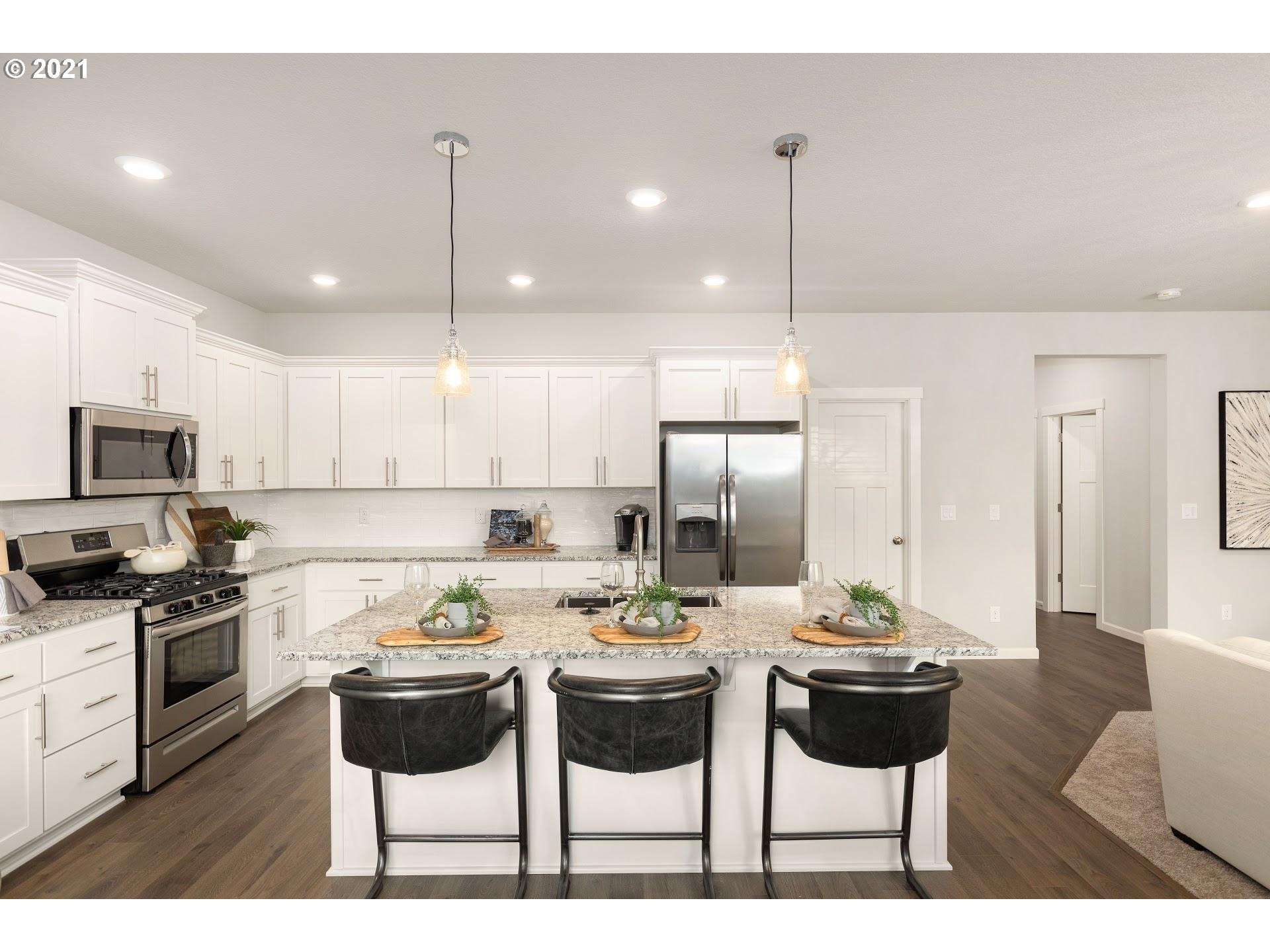 3724 South 42nd Place Ridgefield, WA 98642 - Photo 8 of 31 a kitchen with a dining table chairs stainless steel appliances and cabinets