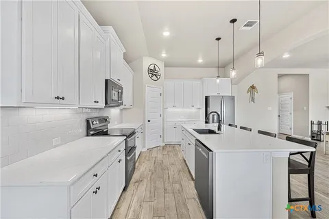 a kitchen with a sink a stove and a refrigerator