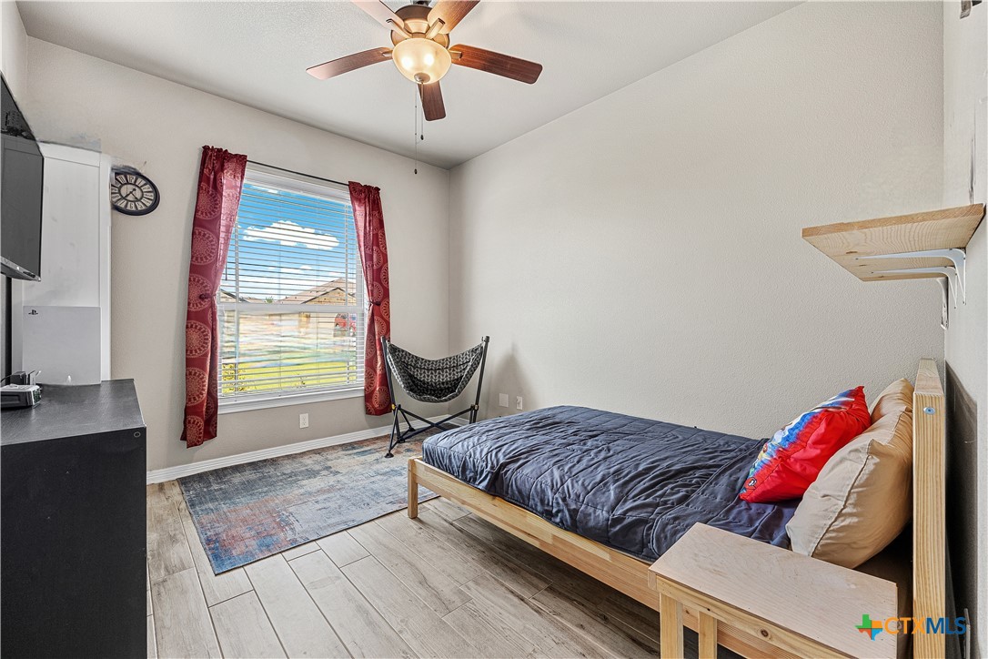 2021 Rustic Manor Drive Temple, TX 76502 - Photo 19 of 30 a bedroom with a bed and a chandelier