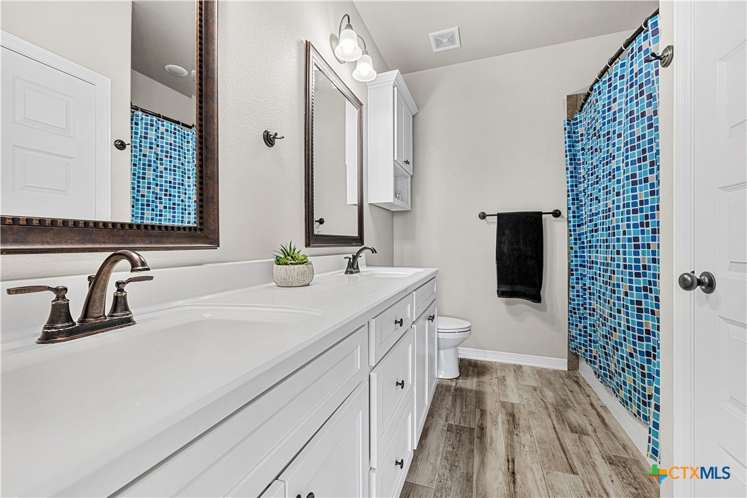2021 Rustic Manor Drive Temple, TX 76502 - Photo 21 of 30 a bathroom with a sink a toilet a mirror and shower