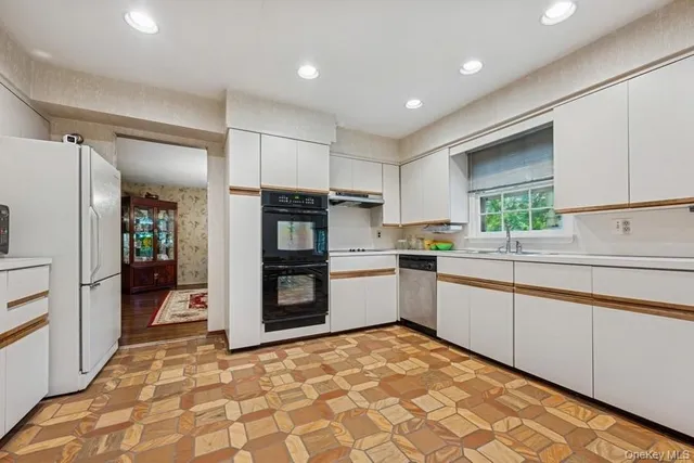 a kitchen with a refrigerator sink and cabinets