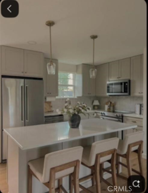 3870 El Hijo Street Riverside, CA 92504 - Photo 2 of 4 a kitchen with stainless steel appliances granite countertop a dining table chairs and white cabinets