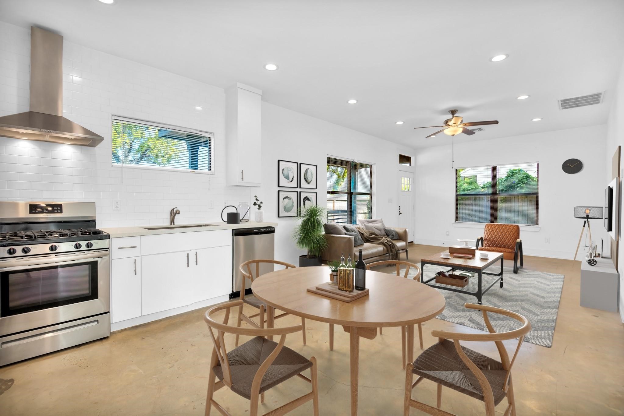 Sun-drenched open living area features soaring ceilings, polished concrete floors, and expansive windows that flood the space with natural light.