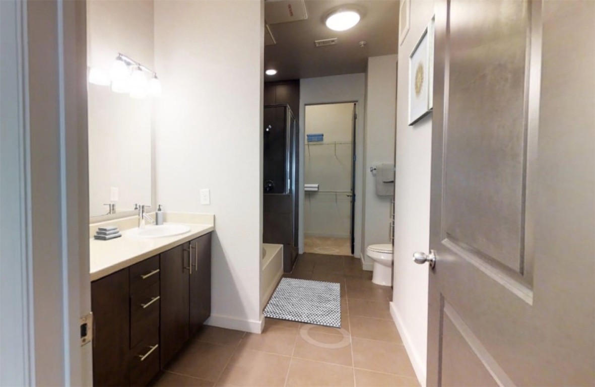 2525 McCue Road, Unit 112 Houston, TX 77056 - Photo 13 of 32 a bathroom with a double vanity sink a toilet and a mirror