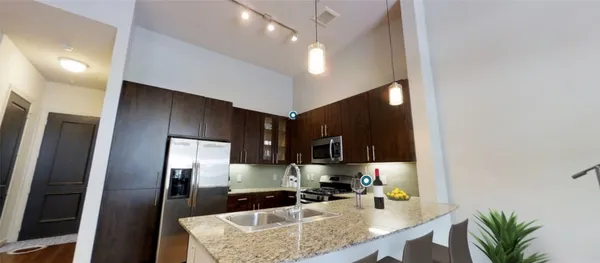 a kitchen with stainless steel appliances granite countertop a sink stove and microwave