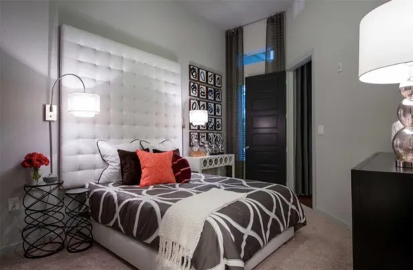 a spacious bedroom with a bed and a chandelier