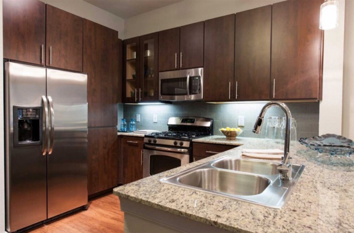 2525 McCue Road, Unit 112 Houston, TX 77056 - Photo 30 of 32 a kitchen with granite countertop a refrigerator and a sink