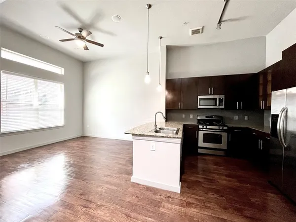 a kitchen with kitchen island a counter space a sink and appliances