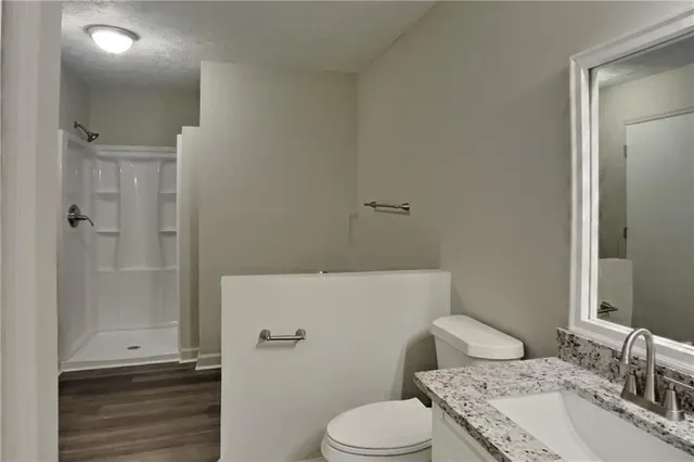 a bathroom with a sink a toilet and shower