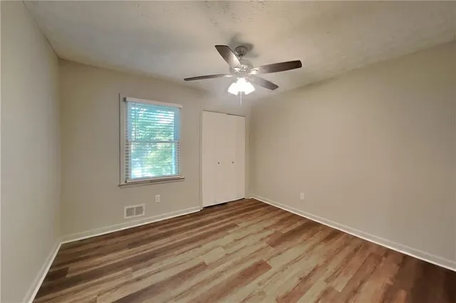 an empty room with a window and a fan