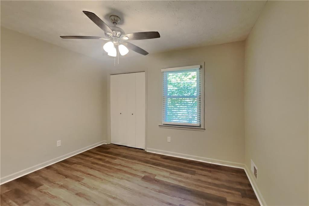 3117 Calumet Circle Northwest Kennesaw, GA 30152 - Photo 16 of 21 an empty room with wooden floor fan and windows