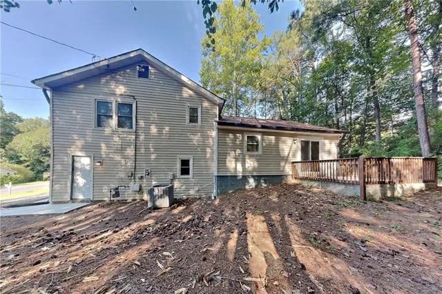 a front view of house with yard and trees in the background