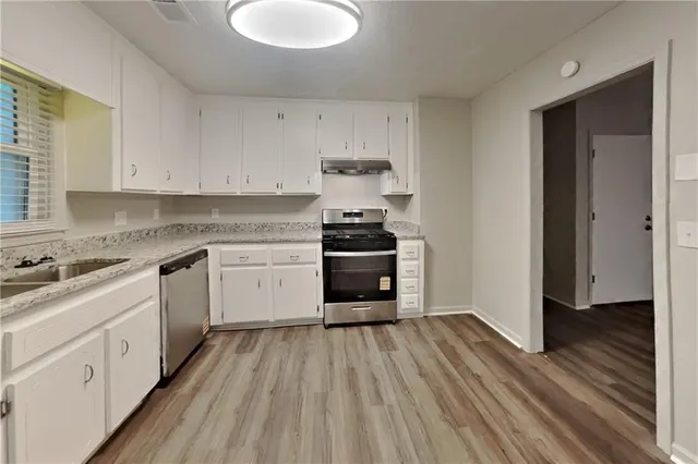 a kitchen with wooden floors and white appliances