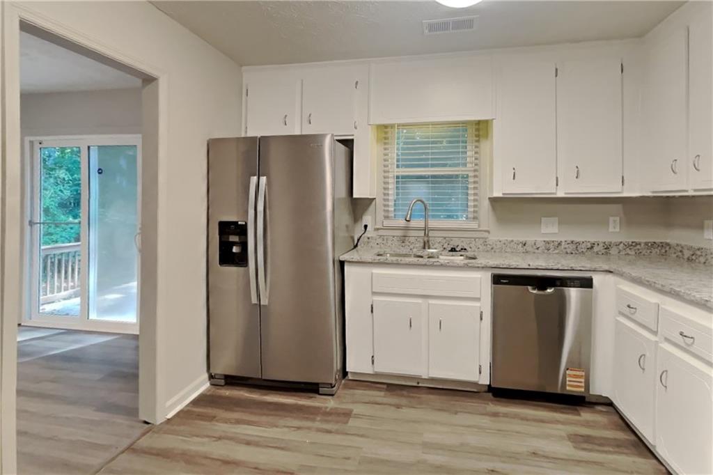 3117 Calumet Circle Northwest Kennesaw, GA 30152 - Photo 6 of 21 a kitchen with granite countertop white cabinets and refrigerator