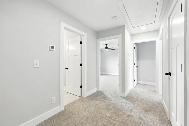 a view of a livingroom with a ceiling fan & windows