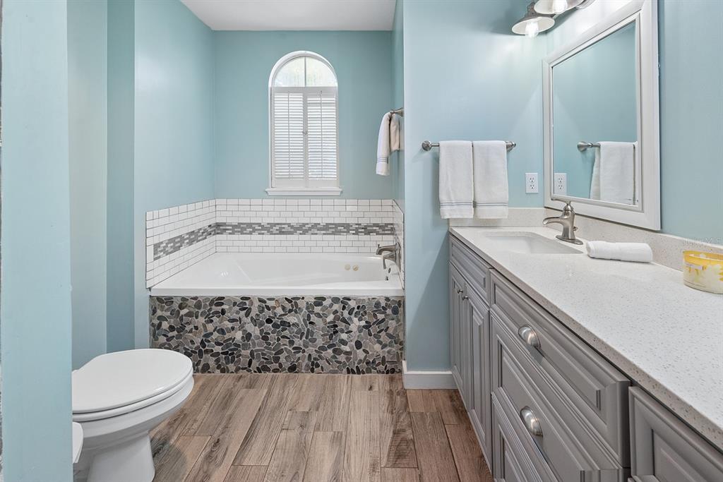 6924 Southwest 80th Drive Gainesville, FL 32608 - Photo 14 of 65 a bathroom with a sink a toilet and mirror
