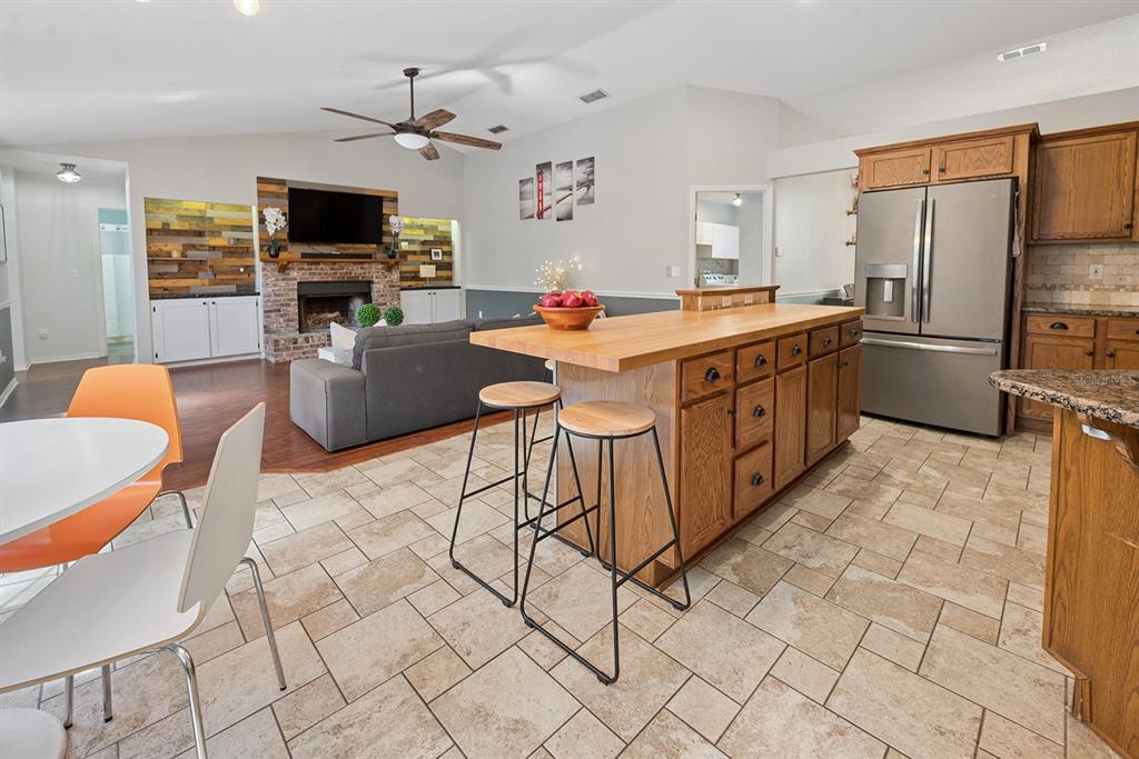 6924 Southwest 80th Drive Gainesville, FL 32608 - Photo 29 of 65 a kitchen with stainless steel appliances kitchen island granite countertop a sink and cabinets